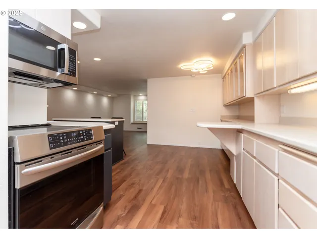 a kitchen with kitchen island a stove and a microwave