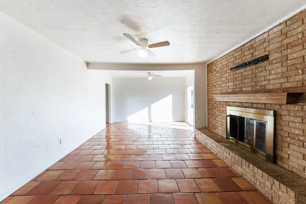 a view of an empty room with window and fire place