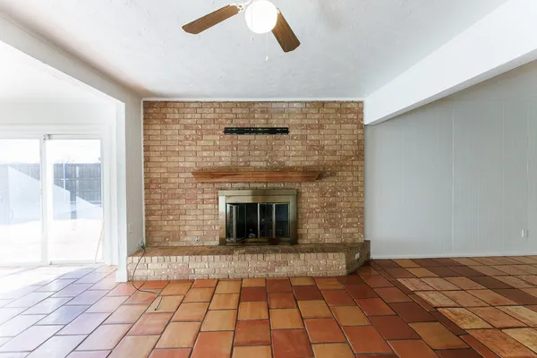 a view of empty room with wooden floor and fireplace