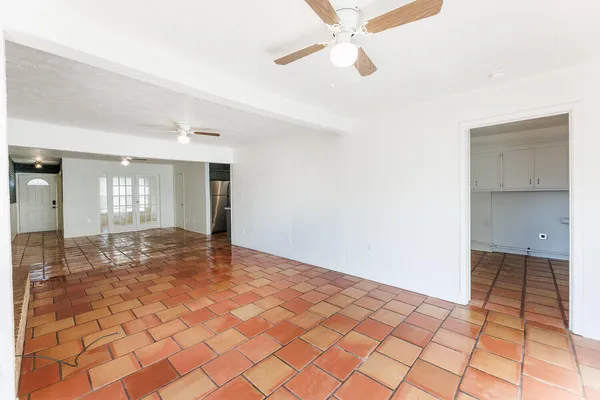 a view of a hallway with a chandelier fan and windows