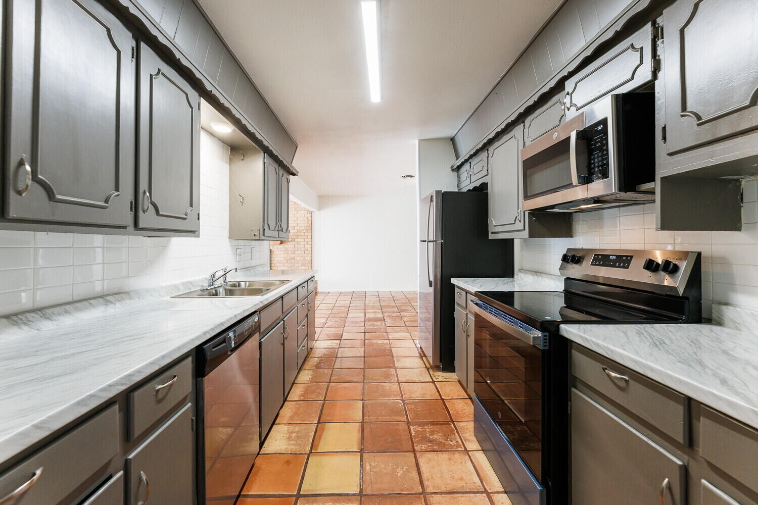 4714 46th Street Lubbock, TX 79414 - Photo 19 of 57 a kitchen with stainless steel appliances granite countertop a sink stove and microwave