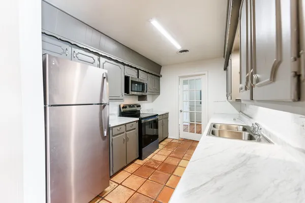 a kitchen with stainless steel appliances a stove microwave and refrigerator
