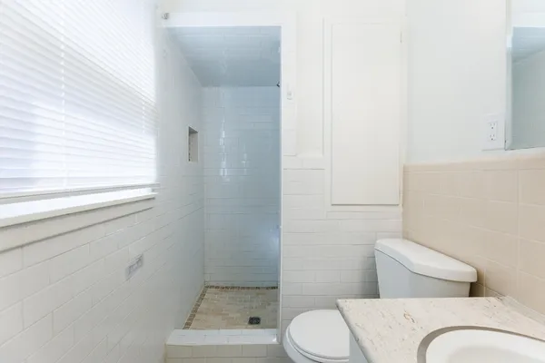 a bathroom with a sink a toilet and a mirror