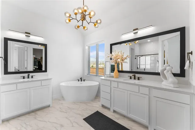 a bathroom with a double vanity sink mirror and bathtub