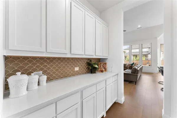 a hallway with white cabinets and couch