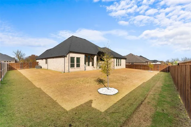 a backyard of a house with table and chairs