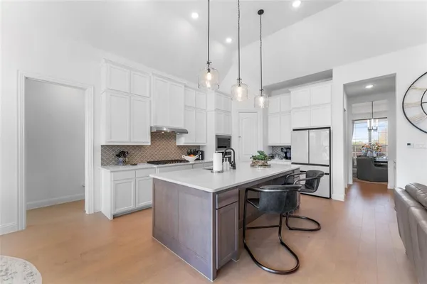 a kitchen with a table chairs refrigerator and cabinets