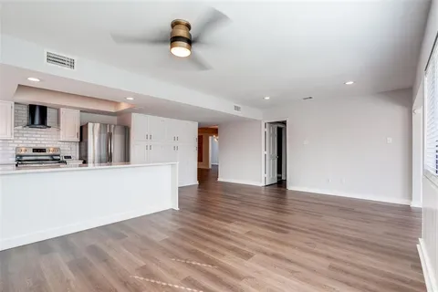 a view of a kitchen with a sink and wooden floor