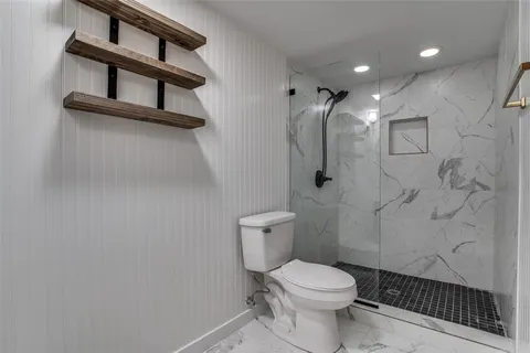 a bathroom with a toilet and a shower