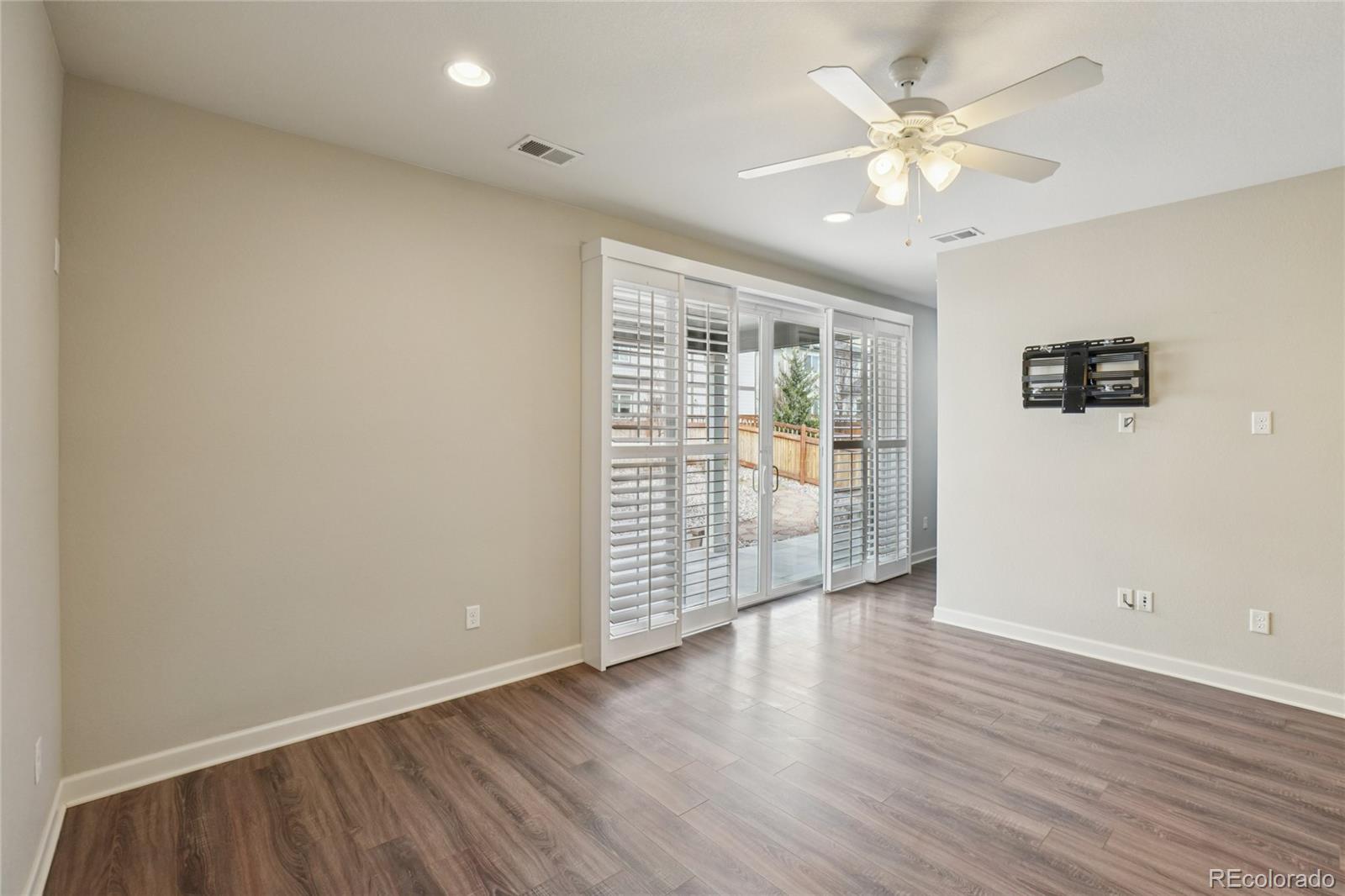 6523 Independence Street Frederick, CO 80516 - Photo 8 of 21 an empty room with wooden floor and windows