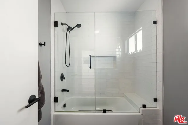 a bathroom with a bath tub with a shower
