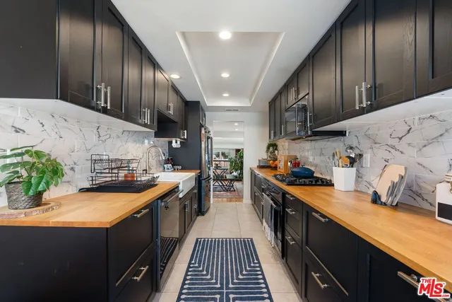 a kitchen with stainless steel appliances granite countertop lots of counter top space a sink and wooden floors