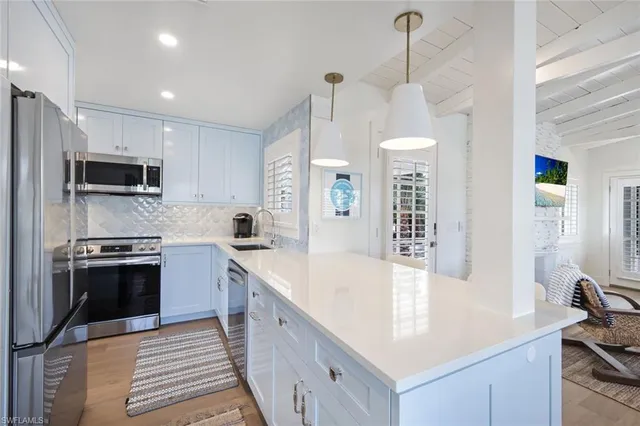 a kitchen with kitchen island granite countertop a sink stove and refrigerator