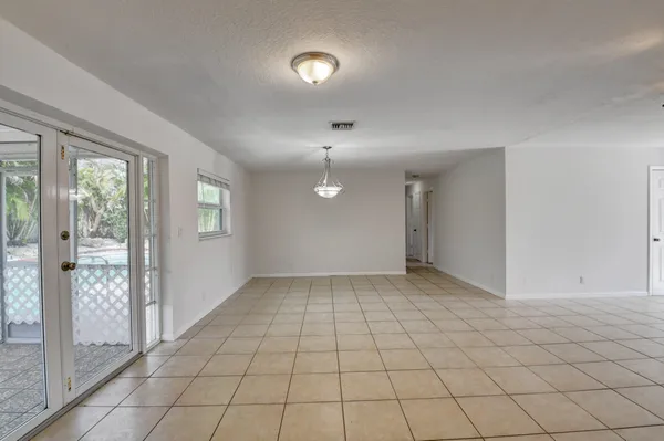 an empty room with windows and ceiling fan