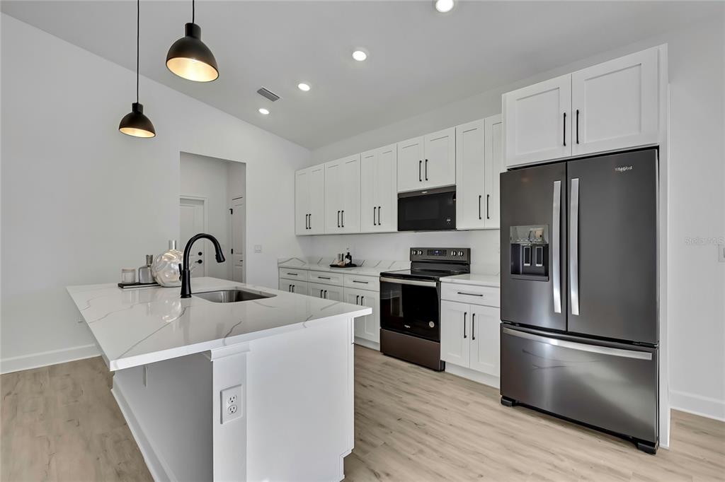 6513 Owl Road Weeki Wachee, FL 34613 - Photo 17 of 47 a kitchen with stainless steel appliances granite countertop a refrigerator a stove a sink and a microwave