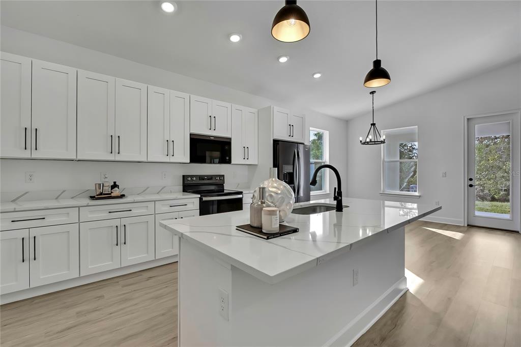 6513 Owl Road Weeki Wachee, FL 34613 - Photo 19 of 47 a kitchen with white cabinets and appliances