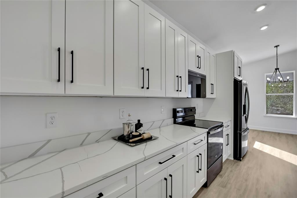 6513 Owl Road Weeki Wachee, FL 34613 - Photo 20 of 47 a kitchen with stainless steel appliances white cabinets and a stove top oven