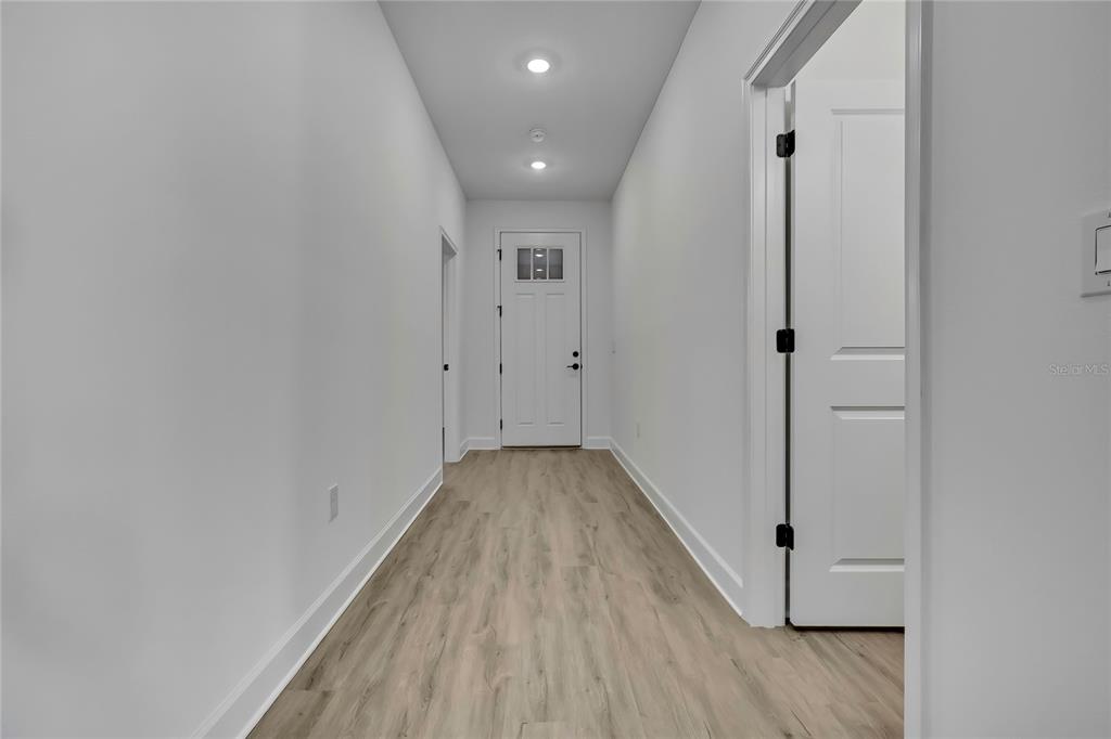 6513 Owl Road Weeki Wachee, FL 34613 - Photo 7 of 47 a view of a hallway with wooden floor