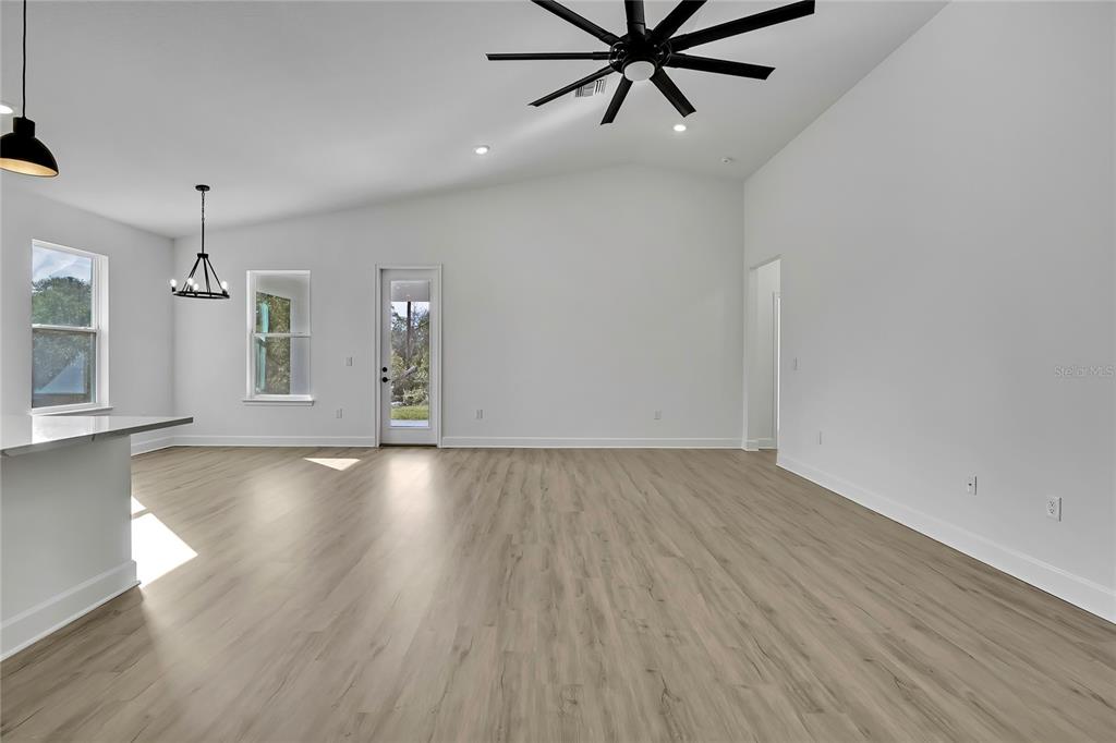 6513 Owl Road Weeki Wachee, FL 34613 - Photo 9 of 47 an empty room with wooden floor and windows