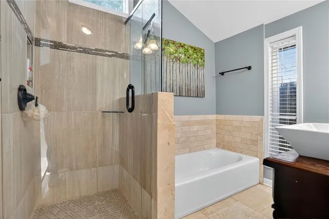 a bathroom with a tub a sink and a shower