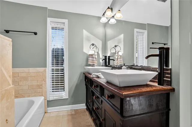 a bathroom with a granite countertop sink a toilet a mirror and shower