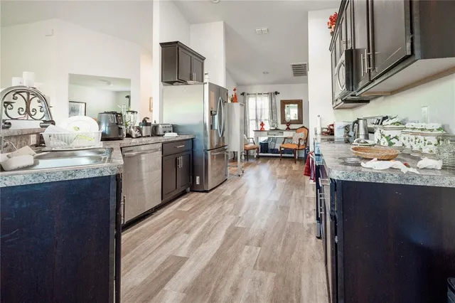a kitchen with kitchen island granite countertop lots of counter top space and stainless steel appliances