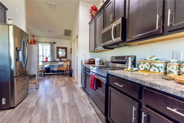 a kitchen with stainless steel appliances granite countertop a refrigerator a stove top oven a sink and dishwasher