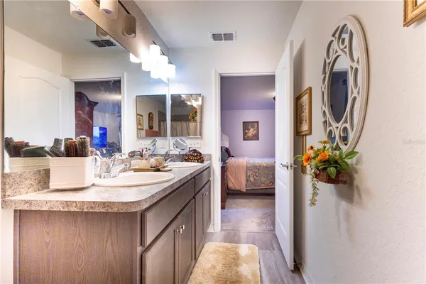 a spacious bathroom with a sink double vanity granite and a mirror