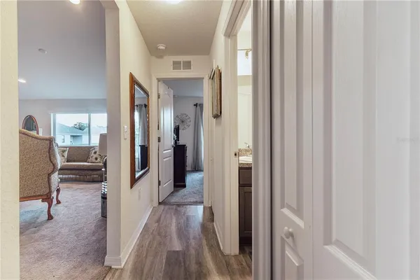 a view of a hallway with wooden floor and furniture