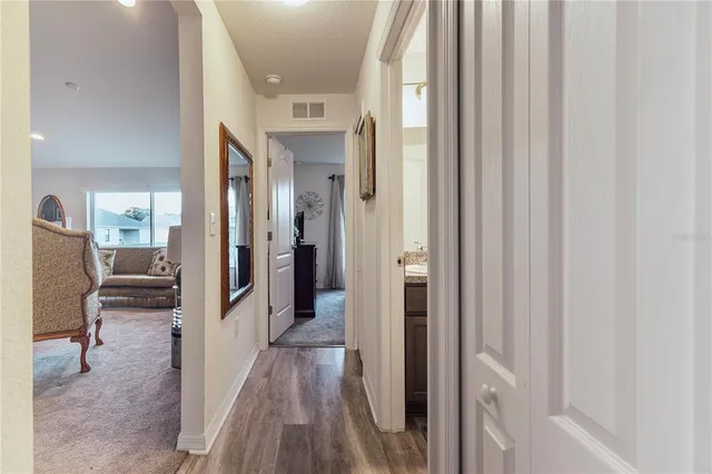 a view of a hallway with wooden floor and furniture