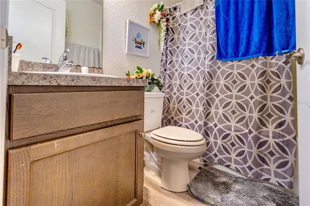a bathroom with a granite countertop toilet and a sink