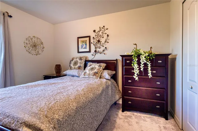 a bedroom with a bed and a lamp on dresser