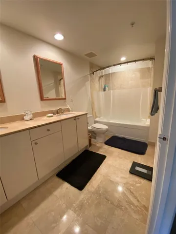 a bathroom with a sink a toilet a mirror and shower