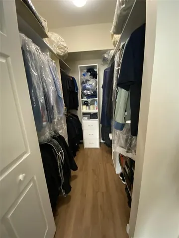 a view of walk in closet with clothes and shoes