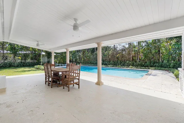 a view of a patio with a table chairs and a swimming pool