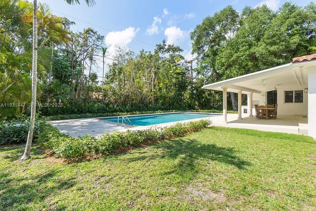a view of a house with swimming pool and a yard