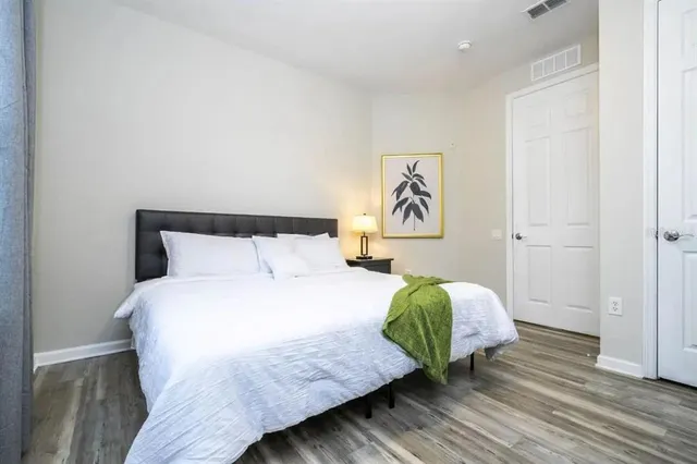 a bedroom with a bed and wooden floor