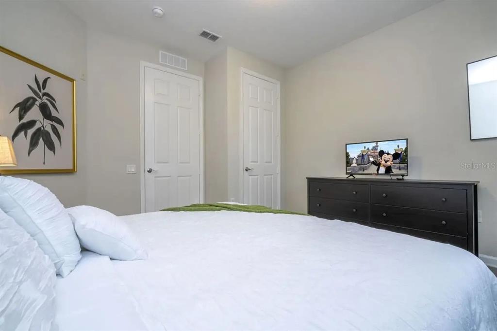 5025 Shoreway Loop, Unit 10703 Orlando, FL 32819 - Photo 15 of 53 a bedroom with a bed and a painting on the wall