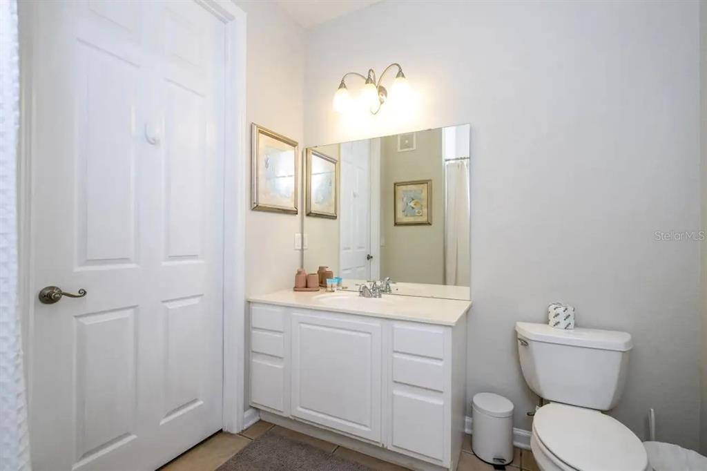 5025 Shoreway Loop, Unit 10703 Orlando, FL 32819 - Photo 16 of 53 a bathroom with a toilet sink and mirror