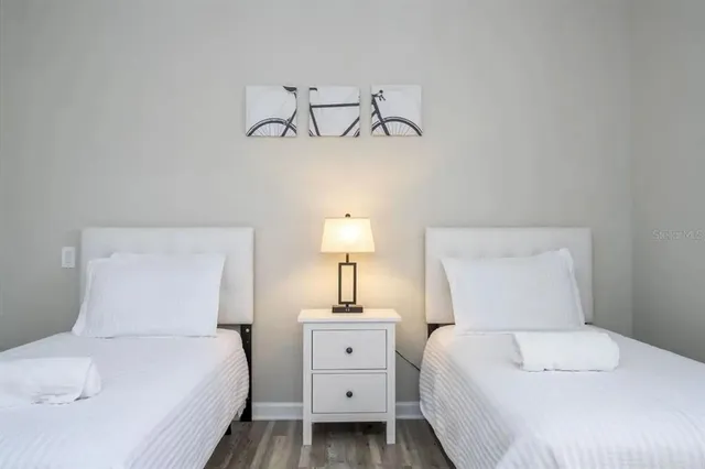 a bedroom with a white bed and a night stand