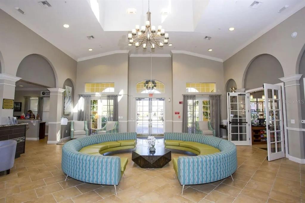 5025 Shoreway Loop, Unit 10703 Orlando, FL 32819 - Photo 29 of 53 a living room with furniture a chandelier and a large window