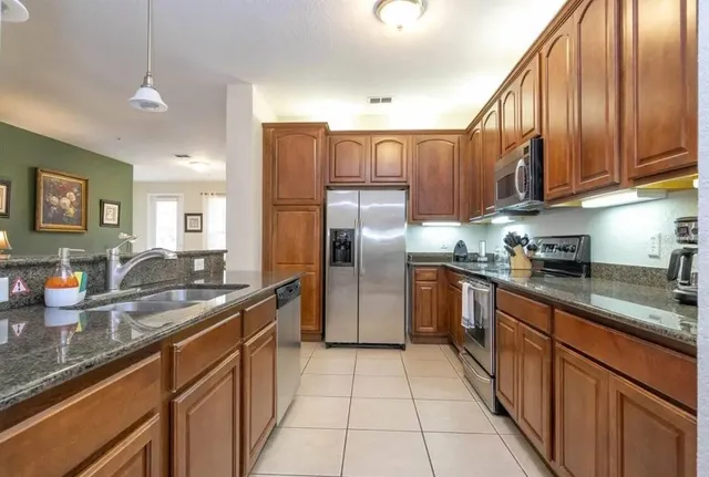 a kitchen with stainless steel appliances granite countertop a refrigerator a sink dishwasher with a stove and cabinets