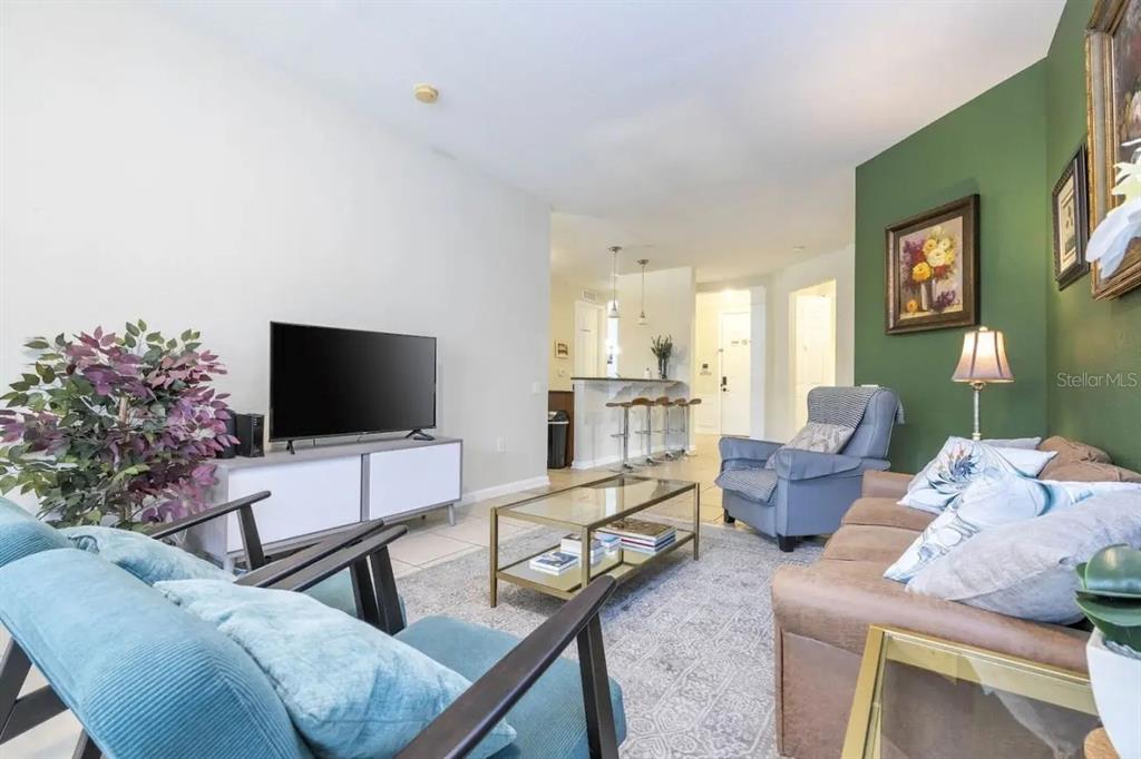5025 Shoreway Loop, Unit 10703 Orlando, FL 32819 - Photo 6 of 53 a living room with furniture and a flat screen tv