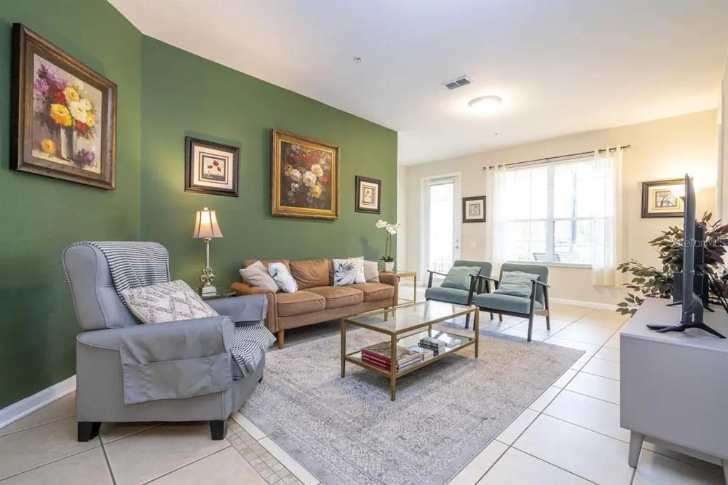 5025 Shoreway Loop, Unit 10703 Orlando, FL 32819 - Photo 7 of 53 a living room with furniture and a large window
