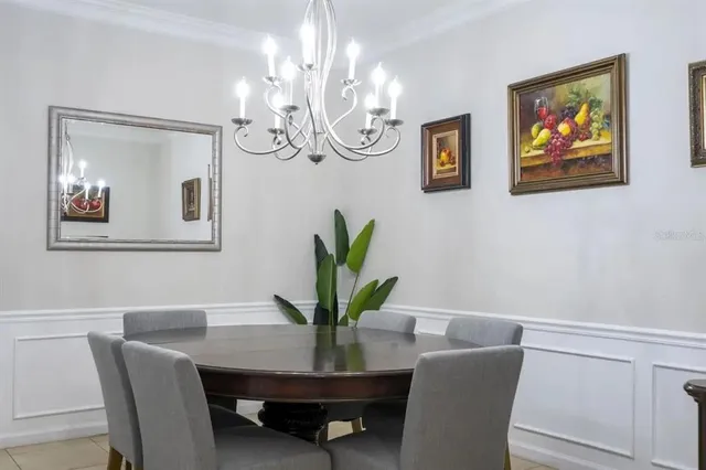 a view of a dining room with furniture a chandelier and wooden floor