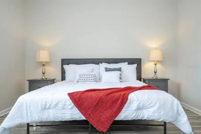 a bedroom with a bed and wooden floor