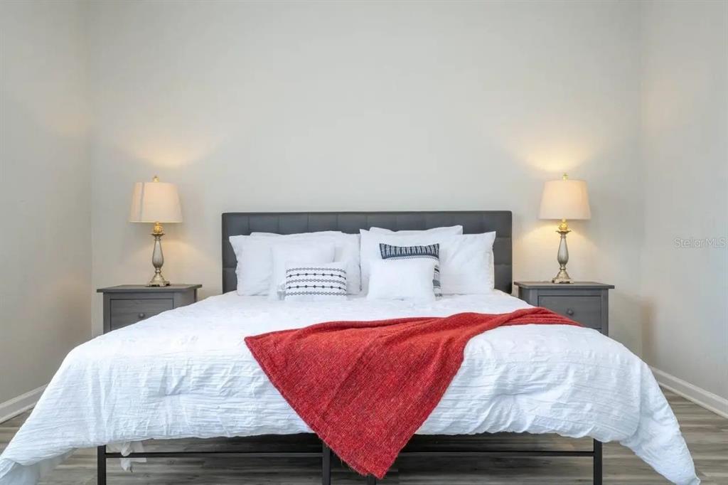 5025 Shoreway Loop, Unit 10703 Orlando, FL 32819 - Photo 10 of 53 a bedroom with a bed and wooden floor