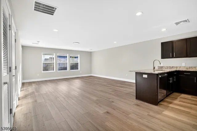 a kitchen with granite countertop a stove and a wooden floor