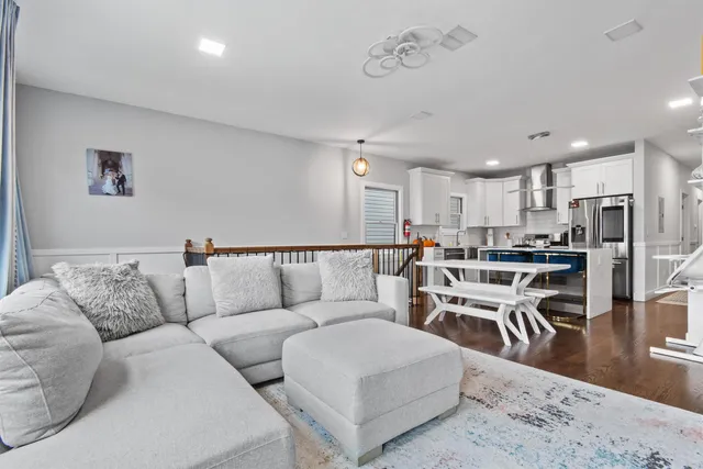 a living room with furniture and a dining table with kitchen view
