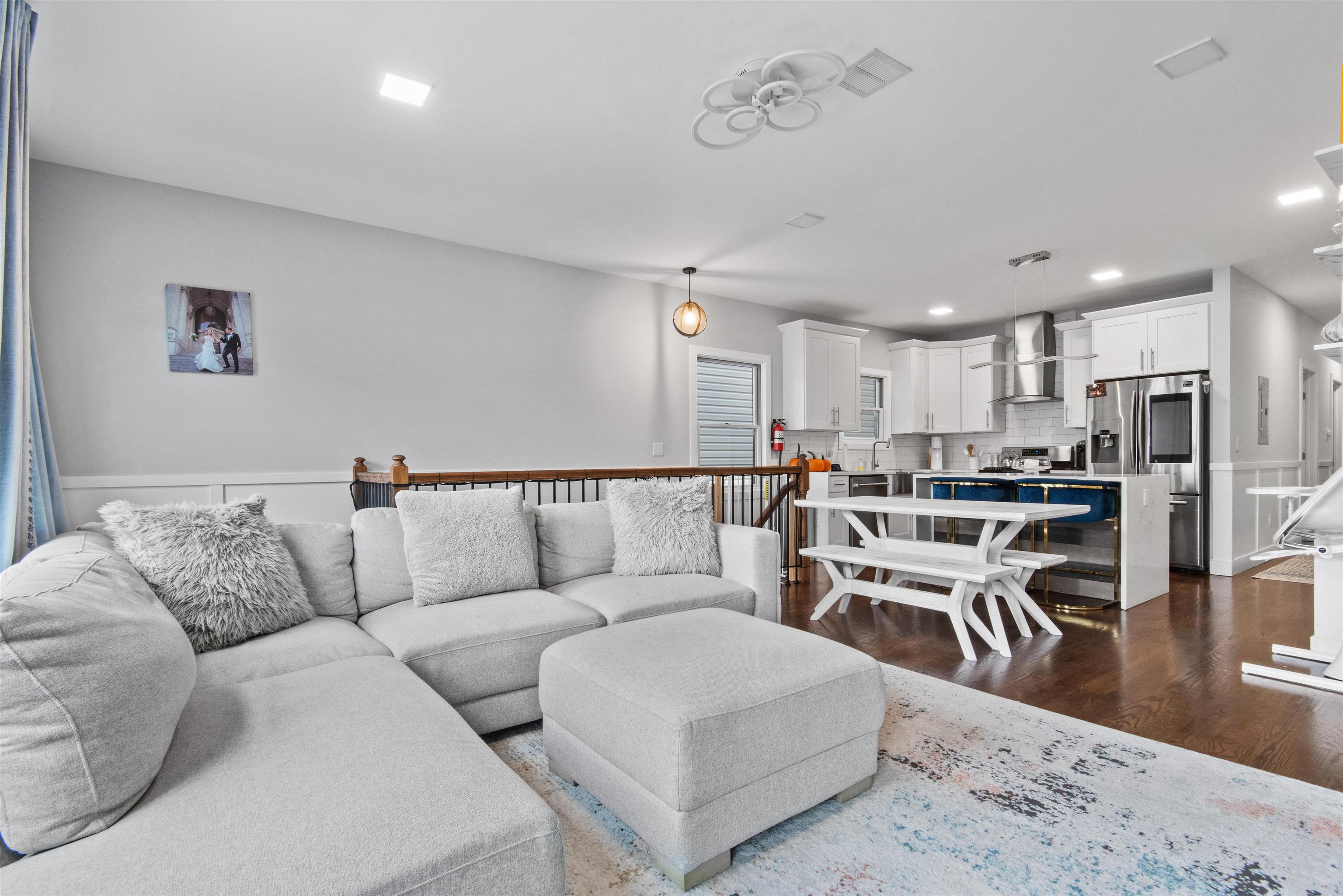 a living room with furniture and a dining table with kitchen view